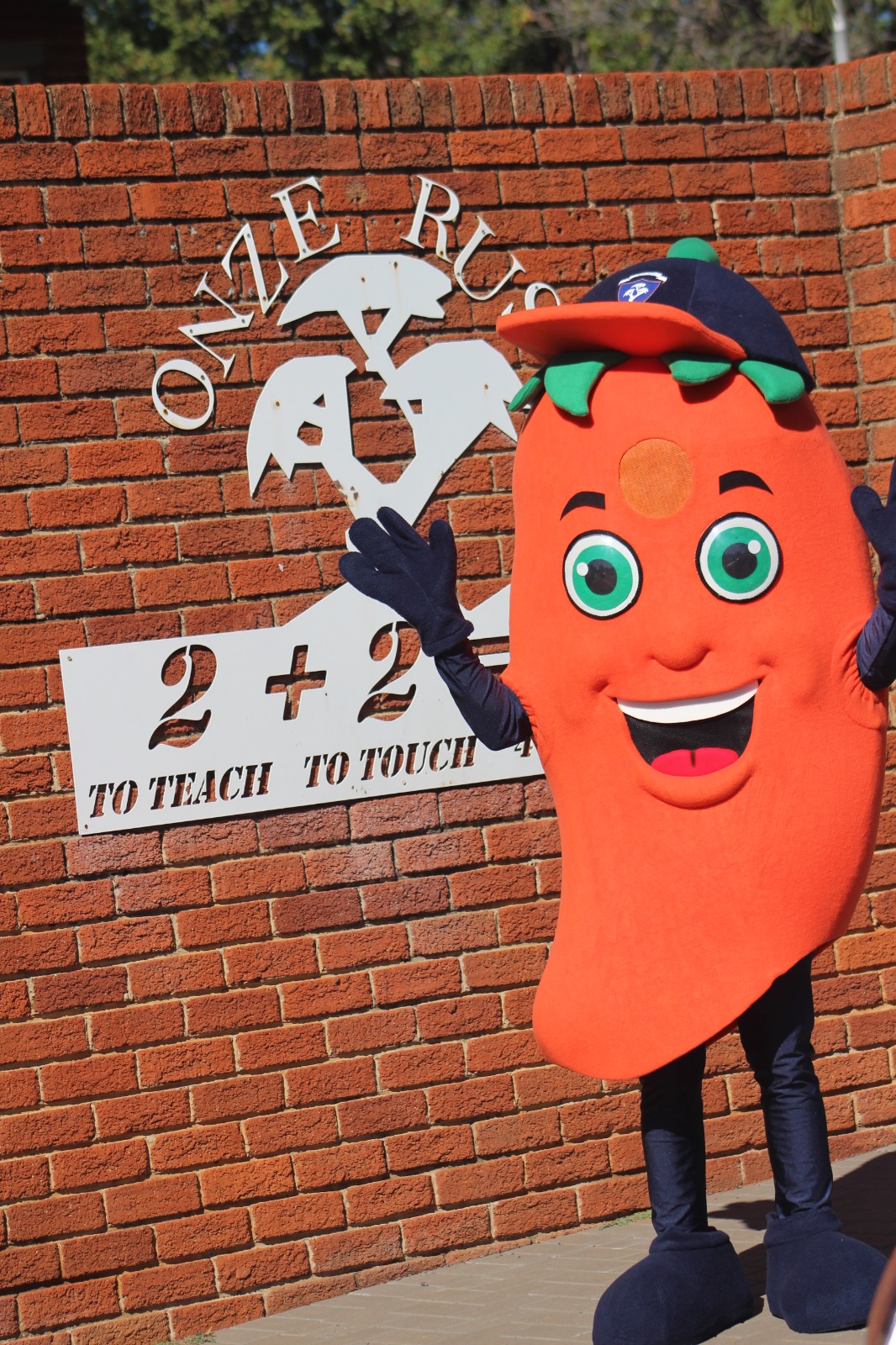 Rissie Rascal mascot outside Onze Rust Primary School